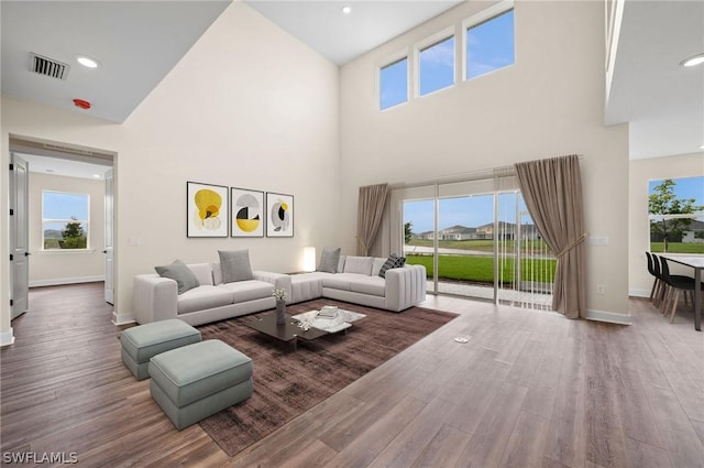 living room featuring wood-type flooring and a towering ceiling