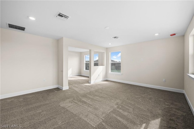 unfurnished room featuring dark colored carpet