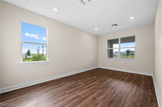 unfurnished room featuring a healthy amount of sunlight and dark hardwood / wood-style floors