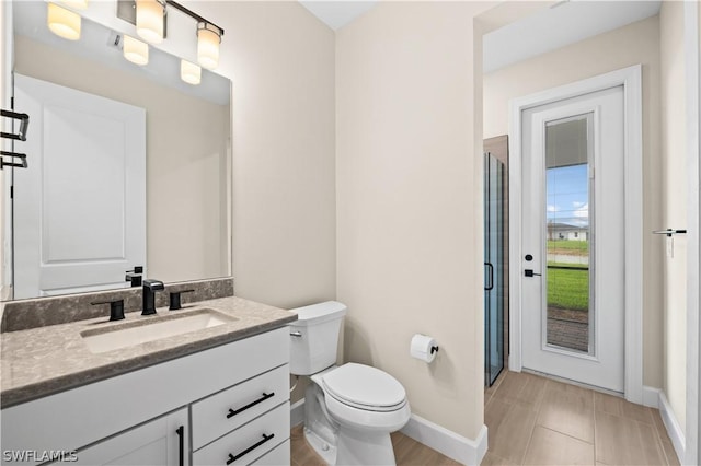 bathroom with toilet, vanity, and tile patterned floors