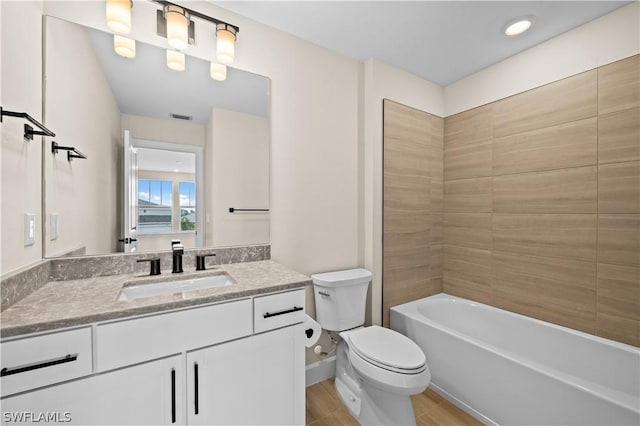 full bathroom with toilet, tiled shower / bath, wood-type flooring, and vanity