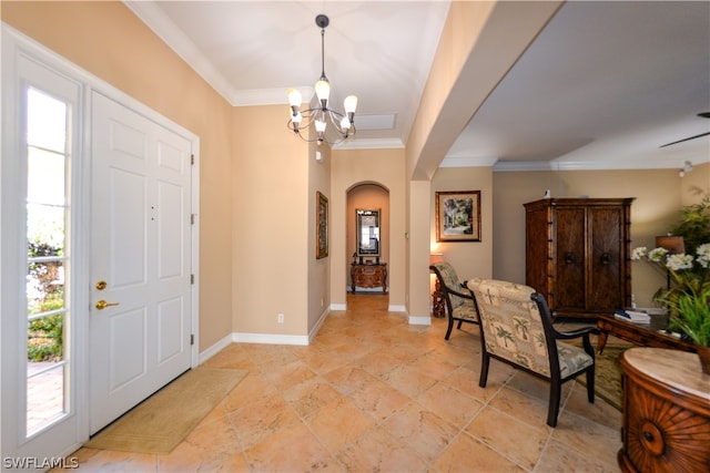 foyer entrance with crown molding, light tile patterned floors, and an inviting chandelier