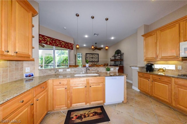 kitchen featuring sink, white appliances, hanging light fixtures, light stone countertops, and kitchen peninsula