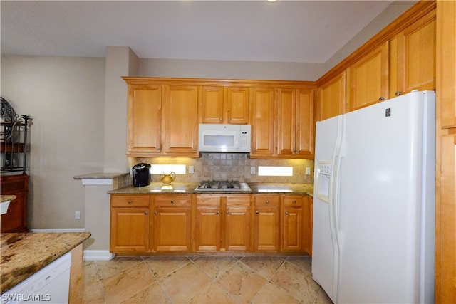 kitchen with light tile patterned flooring, tasteful backsplash, light stone counters, and white appliances