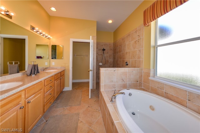 bathroom featuring tiled shower, tile patterned floors, and dual bowl vanity