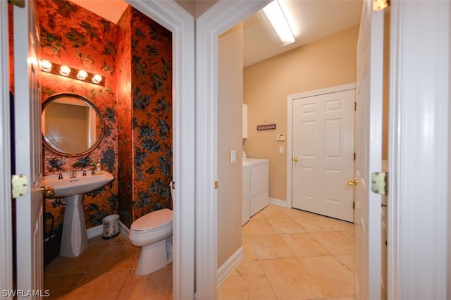 bathroom with sink, toilet, tile patterned floors, and washing machine and dryer