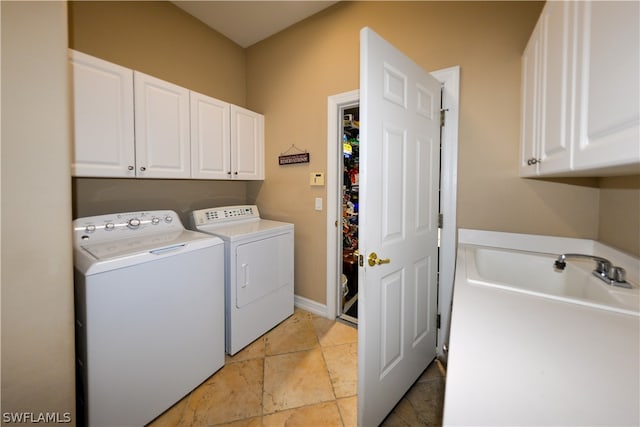 laundry area featuring cabinets, light tile patterned floors, and washing machine and clothes dryer