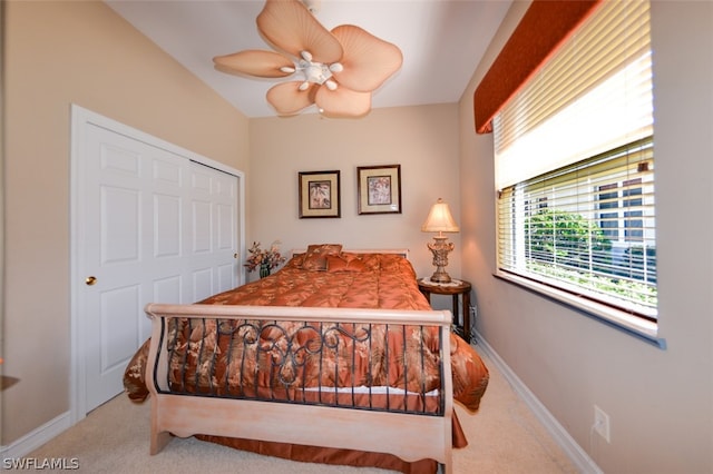 carpeted bedroom with ceiling fan and a closet