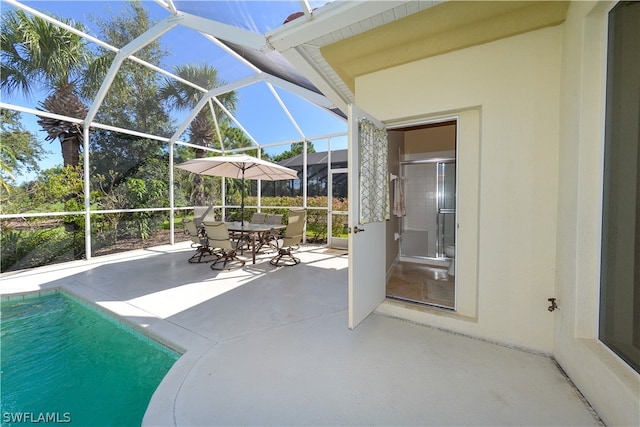 view of pool with a patio and glass enclosure