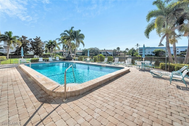 view of swimming pool with a patio and a water view