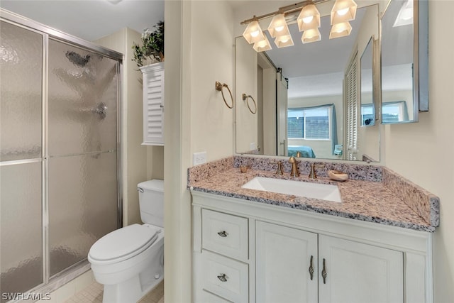 bathroom featuring vanity, a shower with shower door, toilet, and tile patterned floors