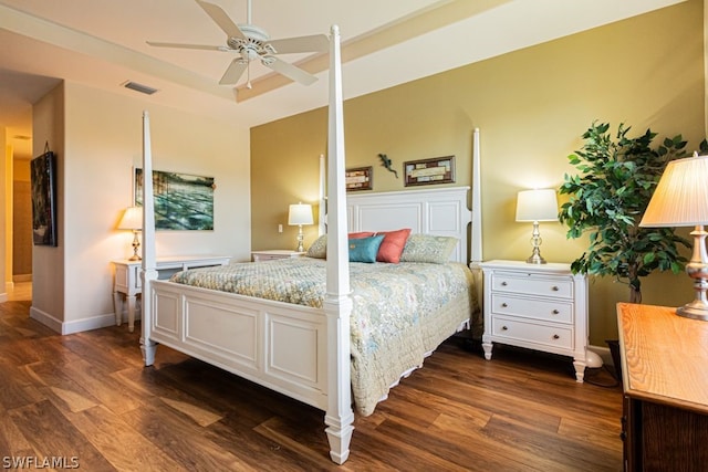 bedroom with dark wood-type flooring, ceiling fan, and a raised ceiling