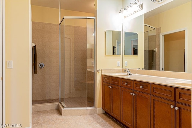 bathroom with a shower with shower door, tile patterned floors, and dual vanity