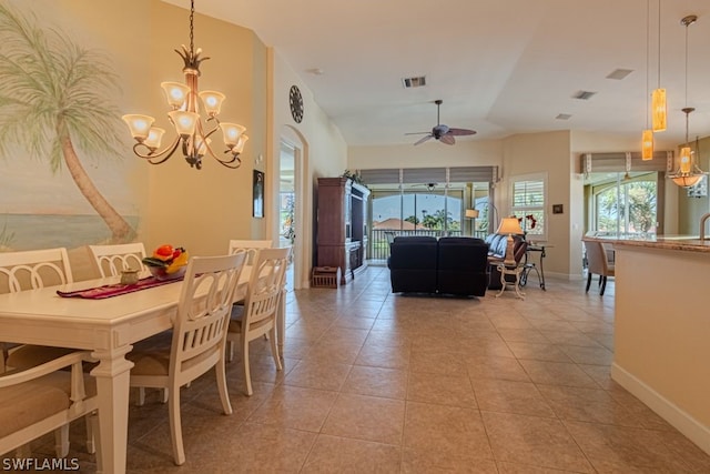 dining room with ceiling fan with notable chandelier, light tile patterned floors, and vaulted ceiling