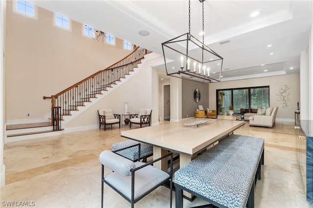 dining space featuring an inviting chandelier, crown molding, and a raised ceiling