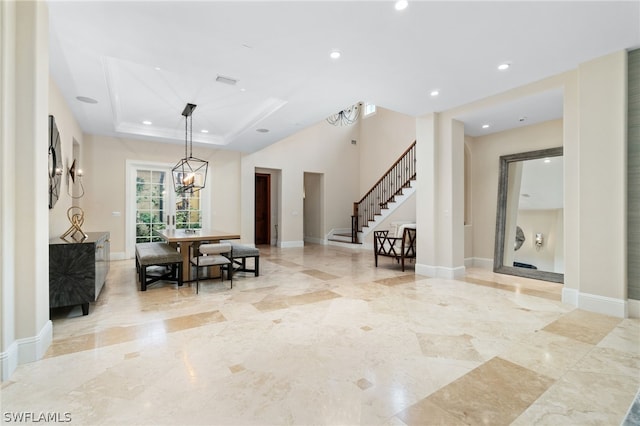 interior space featuring a tray ceiling and a notable chandelier