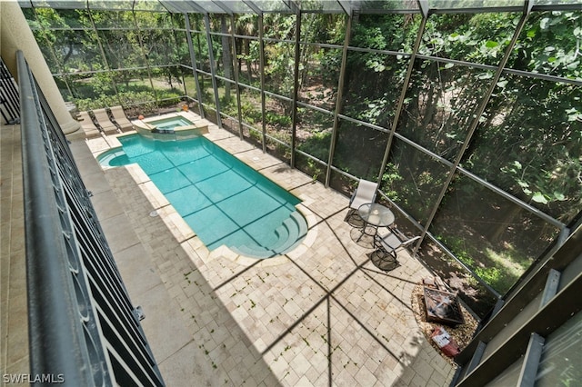 view of swimming pool featuring an in ground hot tub, glass enclosure, and a patio area