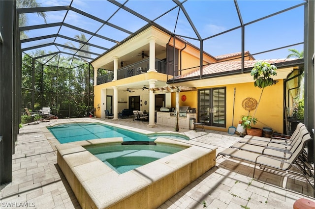 back of property featuring a patio area, area for grilling, a balcony, glass enclosure, and ceiling fan