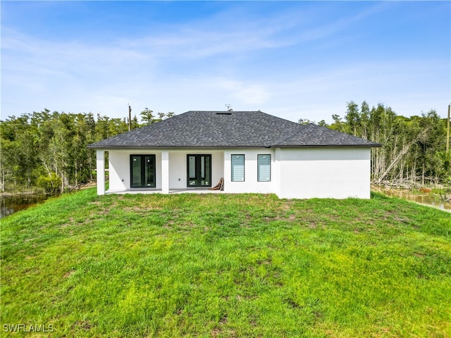 back of property with a patio area and a yard