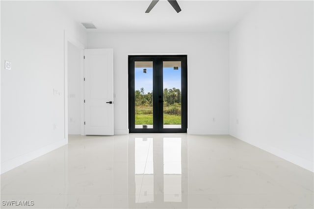 spare room with ceiling fan and french doors