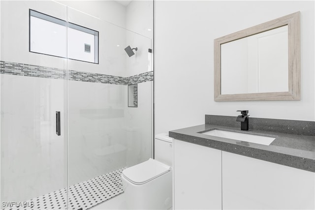 bathroom featuring vanity, toilet, and a shower with shower door