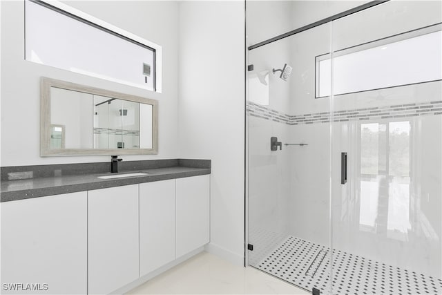 bathroom featuring a shower with door and vanity