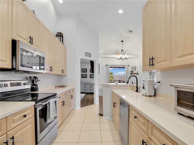 kitchen with stainless steel appliances, sink, light wood-type flooring, light brown cabinetry, and a chandelier