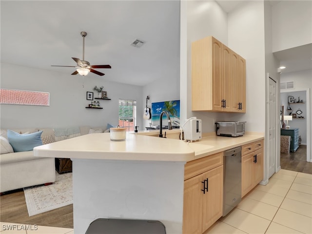 kitchen featuring lofted ceiling, light hardwood / wood-style flooring, light brown cabinets, ceiling fan, and stainless steel dishwasher