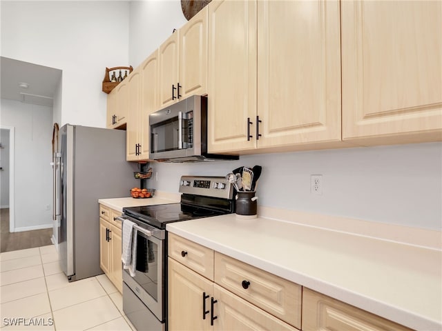 kitchen with appliances with stainless steel finishes, light brown cabinetry, and light wood-type flooring