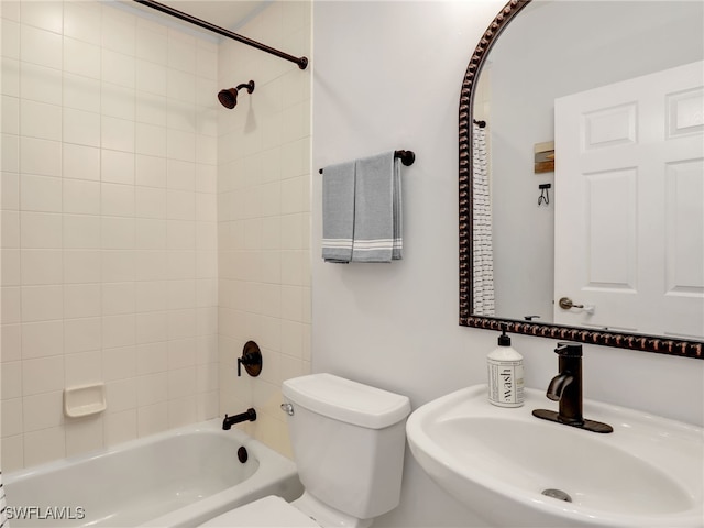 full bathroom with tiled shower / bath combo, toilet, and sink