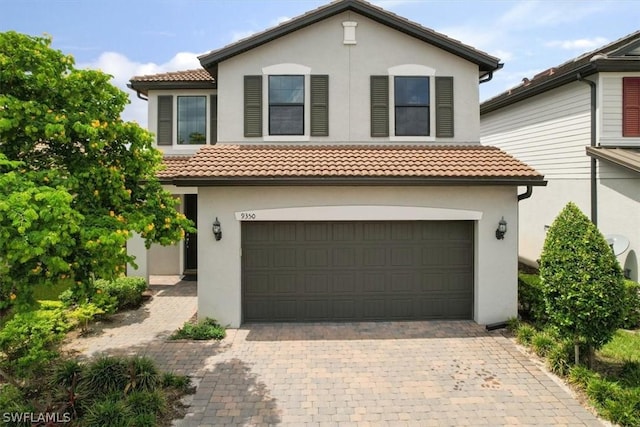 view of front of property with a tiled roof, decorative driveway, and stucco siding