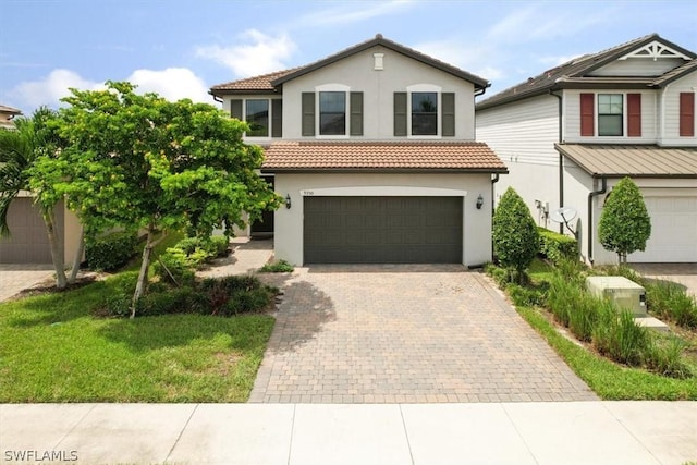 view of front of home featuring a tiled roof, decorative driveway, and stucco siding