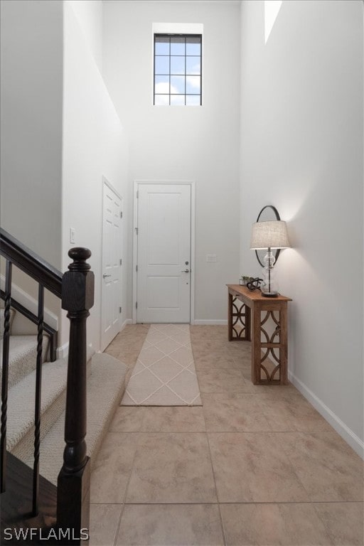 foyer featuring light tile patterned flooring and a high ceiling