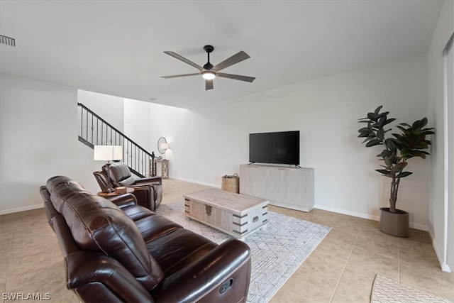 living room featuring stairs, ceiling fan, baseboards, and light tile patterned floors