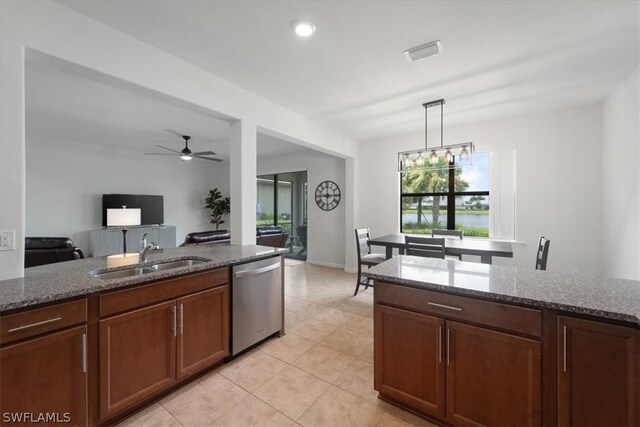 kitchen featuring dark stone counters, a sink, hanging light fixtures, and stainless steel dishwasher