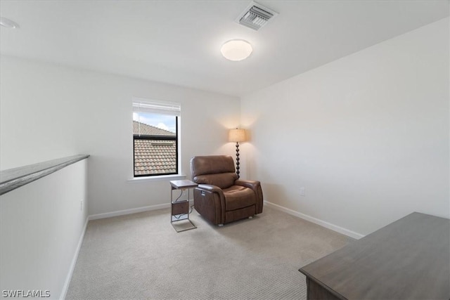 living area featuring baseboards, visible vents, and light colored carpet