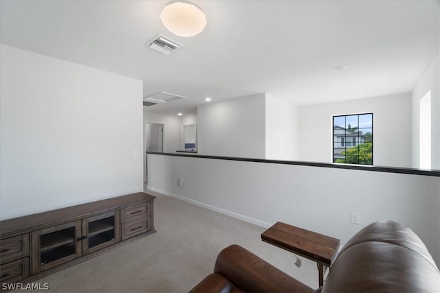 living area with carpet floors, attic access, visible vents, and baseboards