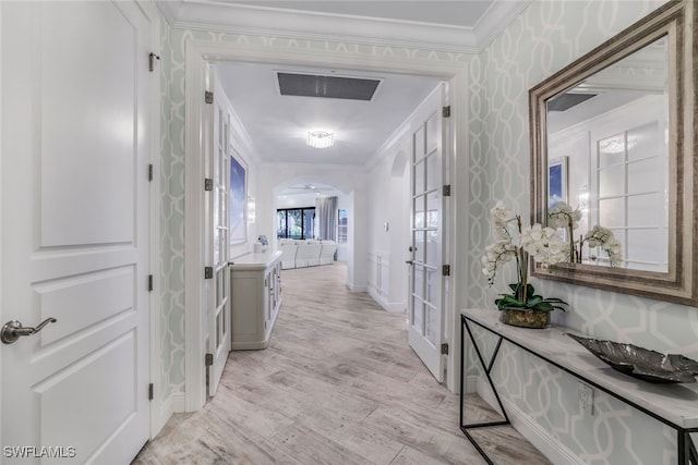 hallway featuring ornamental molding and light hardwood / wood-style floors