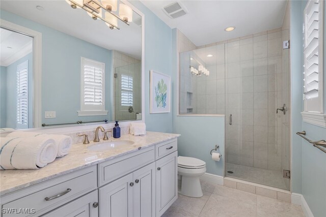 bathroom with a shower with shower door, vanity, tile patterned flooring, and toilet