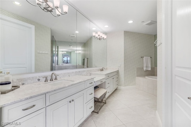 bathroom featuring vanity, tiled bath, tile patterned floors, and an inviting chandelier