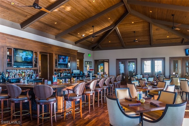 dining space with high vaulted ceiling, french doors, ceiling fan, and bar area