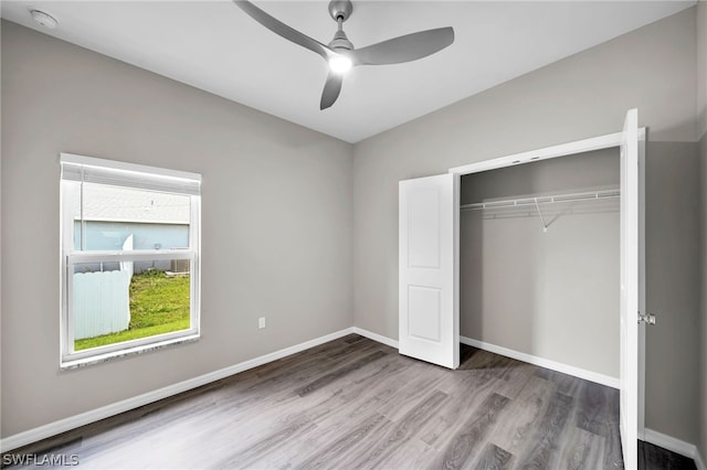 unfurnished bedroom with a closet, hardwood / wood-style floors, and ceiling fan