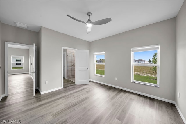 unfurnished bedroom featuring connected bathroom, hardwood / wood-style flooring, and ceiling fan