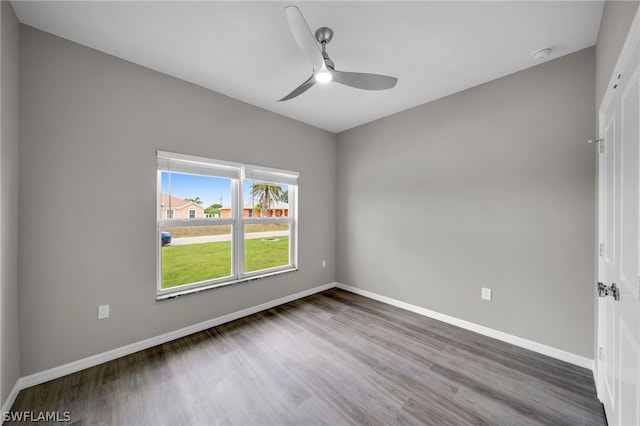 spare room with dark hardwood / wood-style floors and ceiling fan