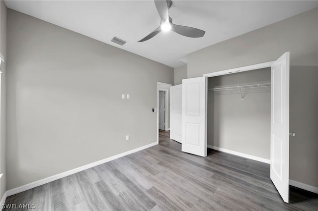 unfurnished bedroom with hardwood / wood-style flooring, a closet, and ceiling fan