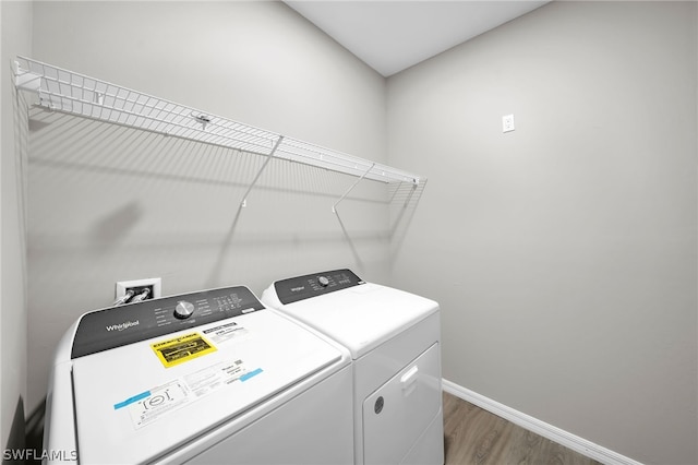 washroom with hardwood / wood-style flooring and independent washer and dryer