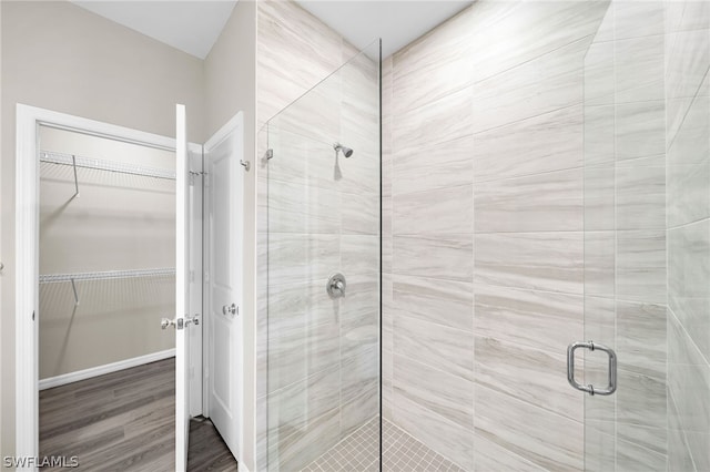 bathroom with walk in shower and hardwood / wood-style floors