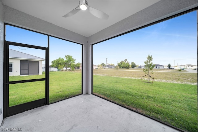 unfurnished sunroom with ceiling fan