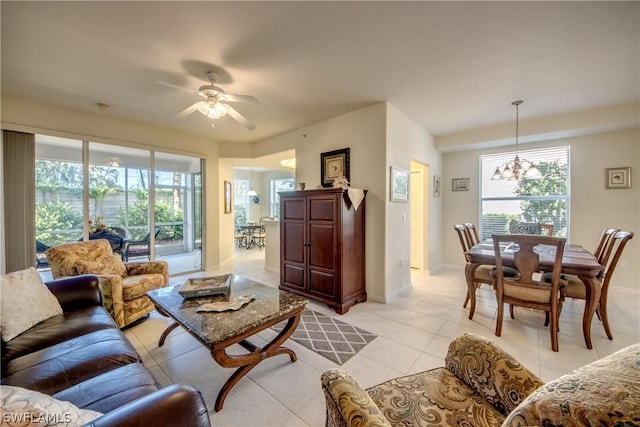 tiled living room featuring ceiling fan with notable chandelier