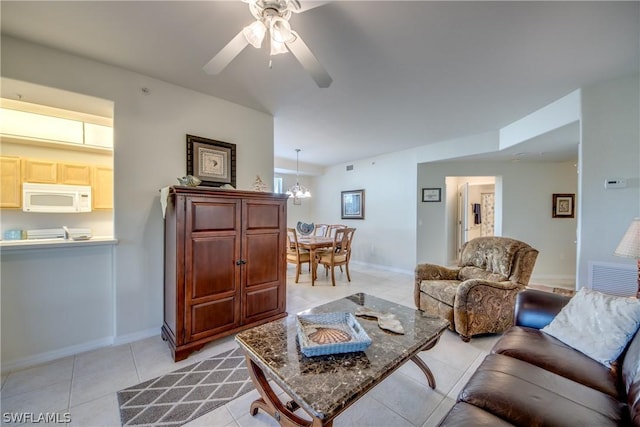 living room featuring ceiling fan with notable chandelier and light tile patterned floors